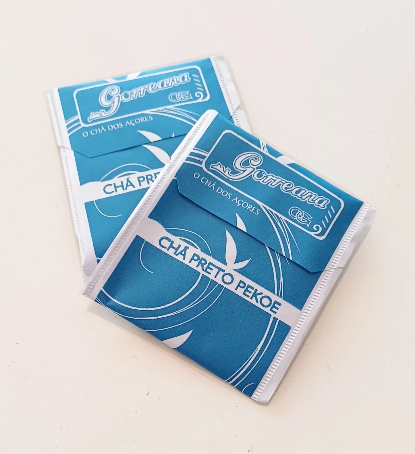 Two blue tea bags labeled Gorreana Cha Preto Pekoe from O Chá dos Açores on white background
