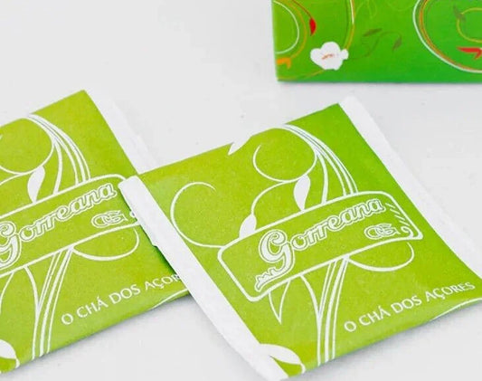 Close-up of green tea sachets labeled Gorreana O Chá Dos Açores with white decorative patterns on a white background