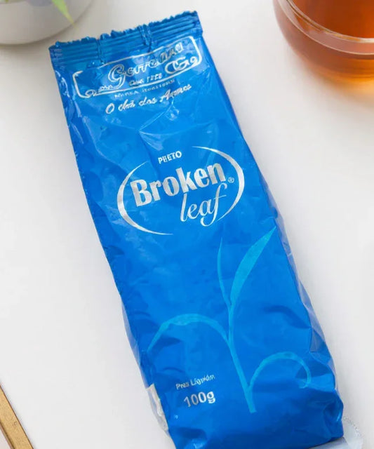 Broken Leaf Pheto green tea 100g blue packaging with a cup of tea on a white surface